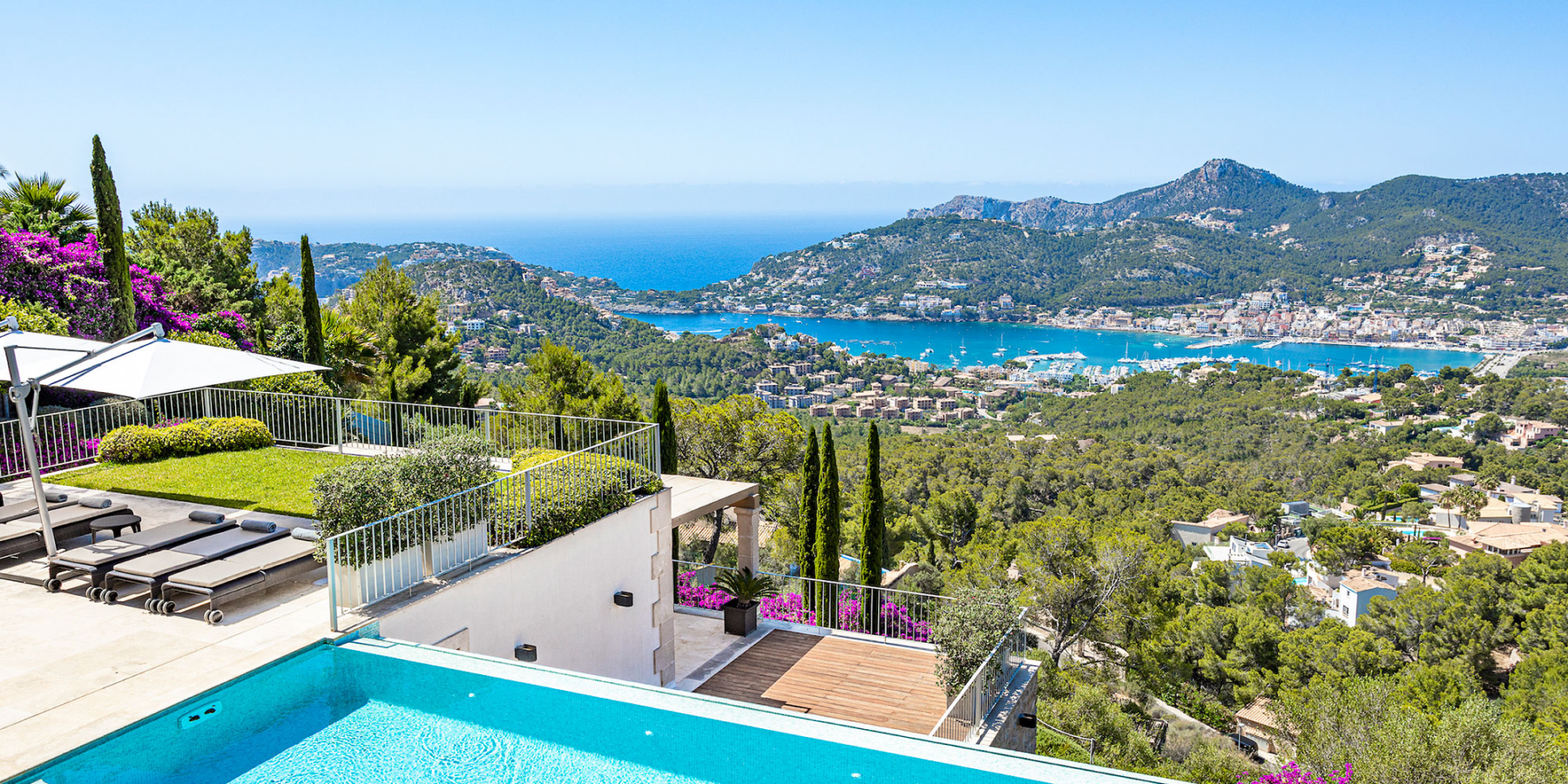 White villas, green trees on a mountain range and the bright blue sea